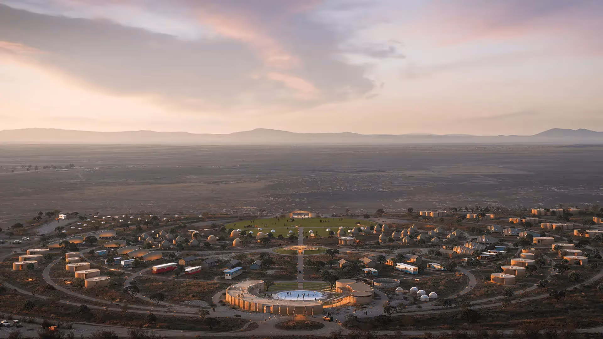Aerial view of circular settlement with domes and cylindrical buildings at sunset