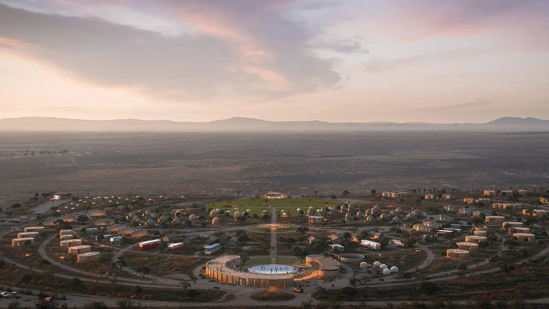 Aerial view of circular settlement with domes and cylindrical buildings at sunset