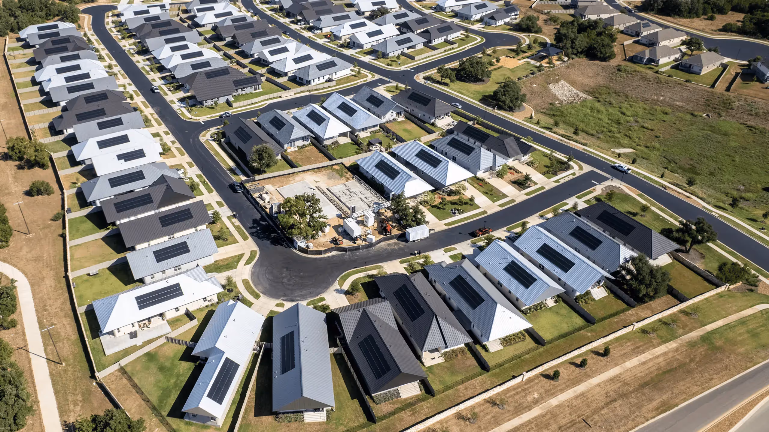Aerial view of a residential neighborhood with single-story homes and rooftop solar panels