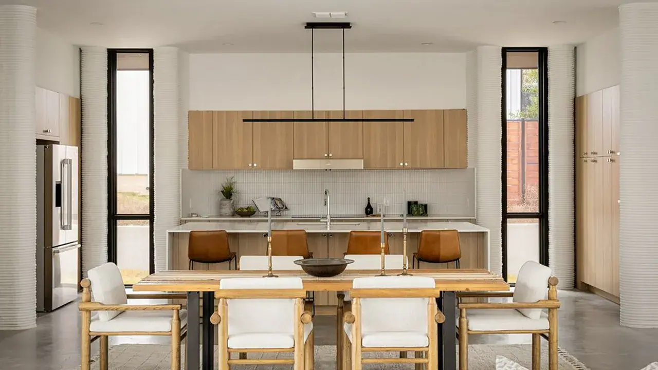 Modern kitchen and dining area with wood cabinets, island seating, and wooden dining chairs