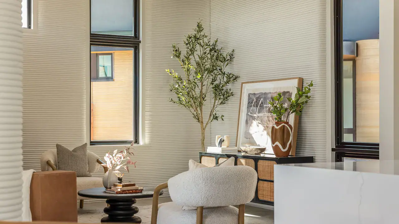 Living room with ribbed walls, lounge chairs, round coffee table, console and potted tree