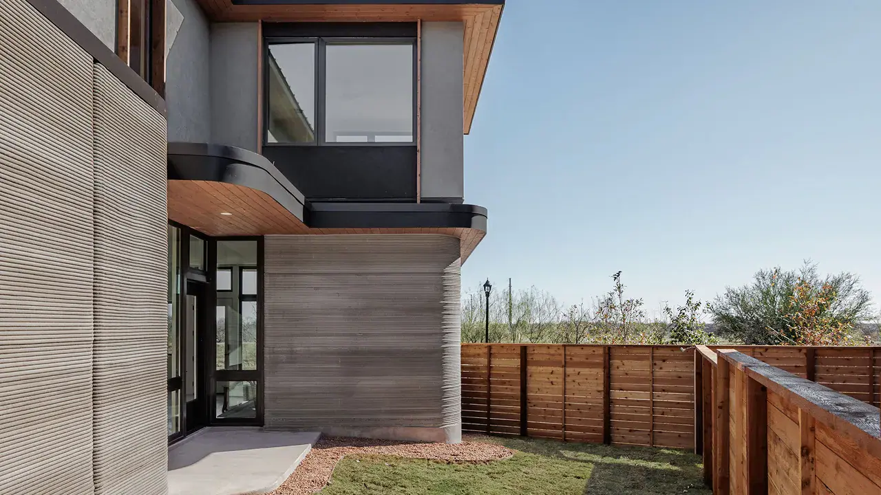 Modern home exterior with textured concrete walls and wooden privacy fence
