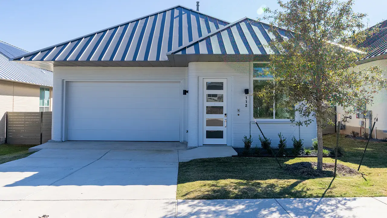 Modern single-story house with metal roof, white exterior, glass-panel front door and two-car garage