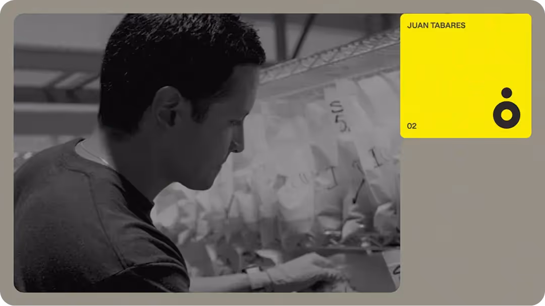 Team member inspecting labeled material bags on shelving in a fabrication workshop, showing hands-on construction tech