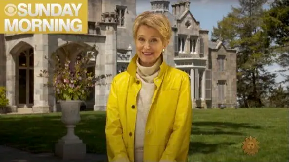 Broadcast host in yellow coat before a stone mansion, Sunday Morning segment highlighting architecture and design