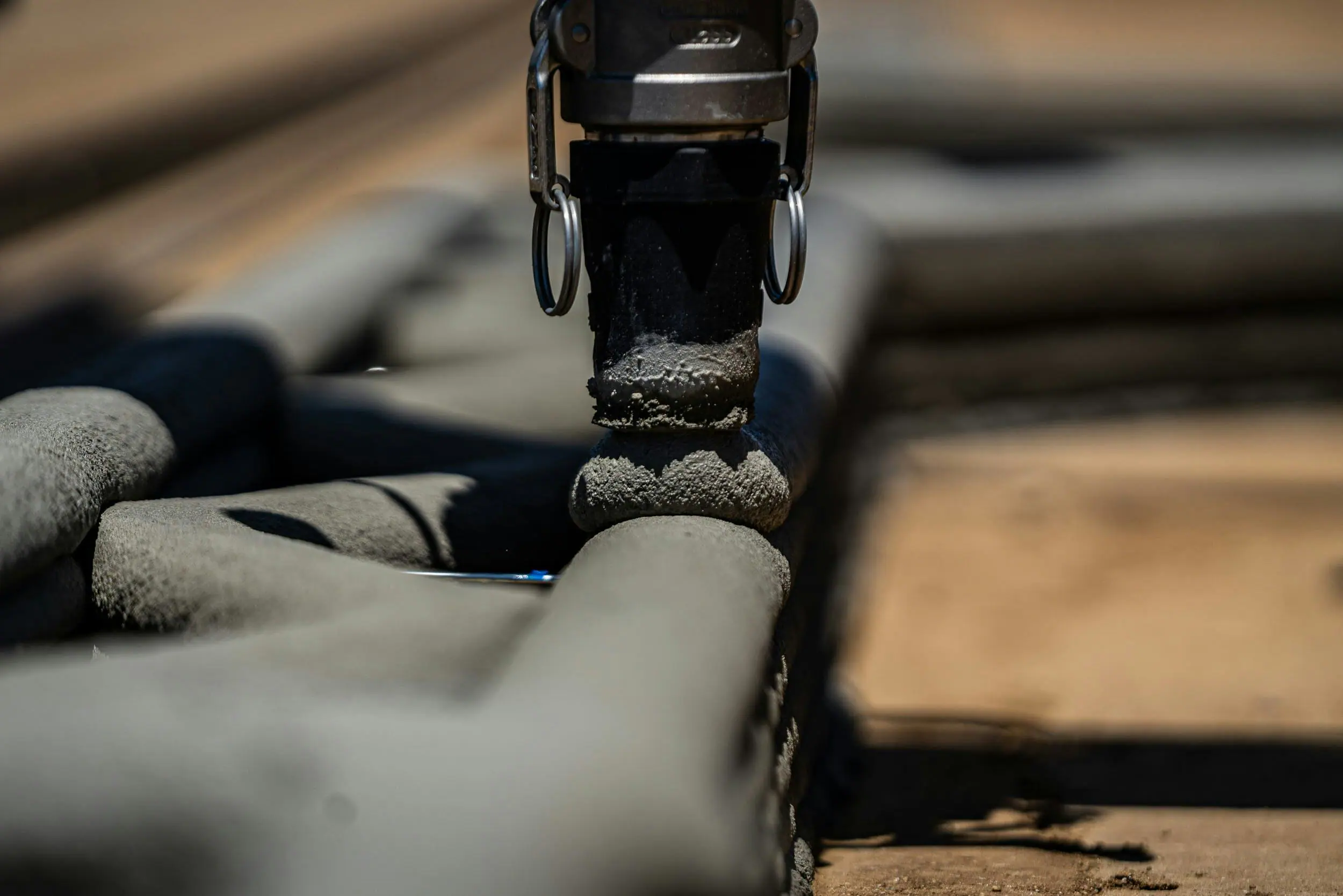 Robotic 3D-printing nozzle extruding concrete layers for automated wall construction