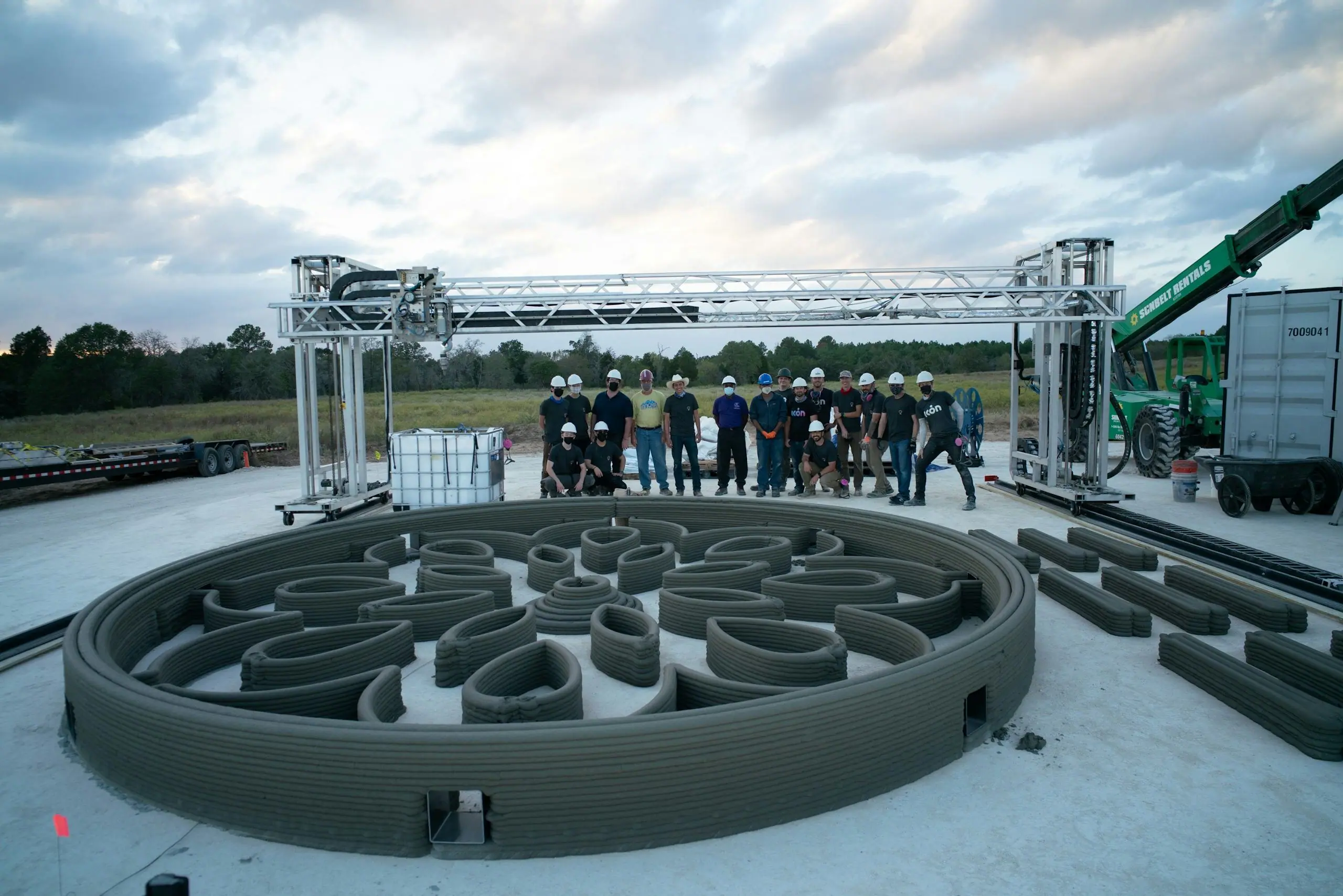 Circular 3D-printed concrete walls with crew and gantry robot printer demonstrating on-site construction.