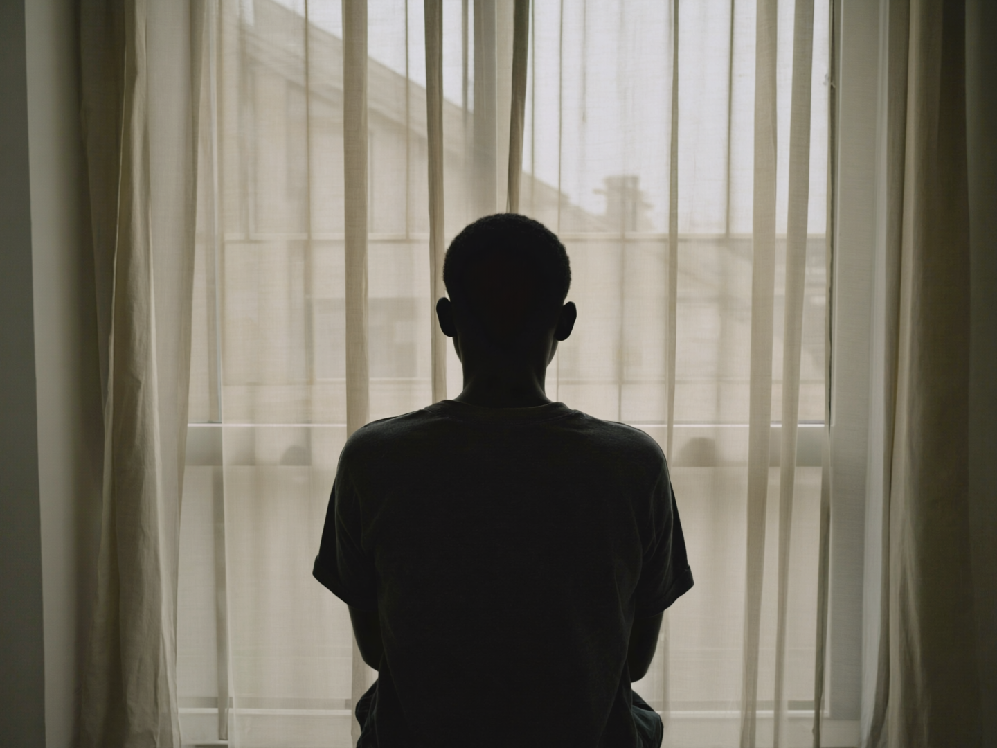 Smiling male therapist takes notes while listening to a couple during a counseling session.