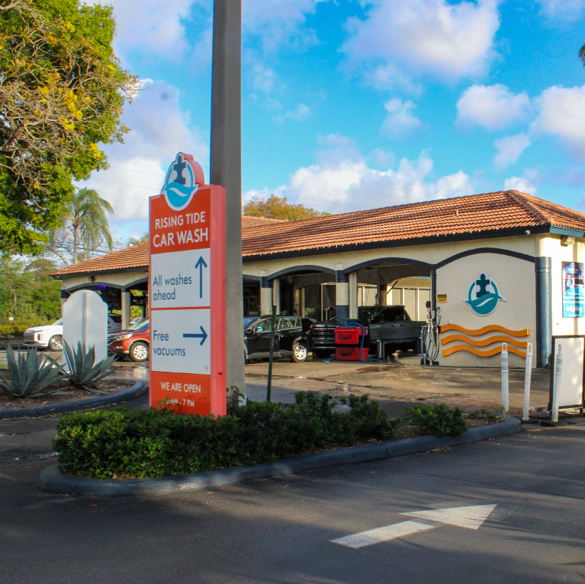 Rising Tide Car Wash Parkland storefront with brand pylon sign and palm trees on State Road 7