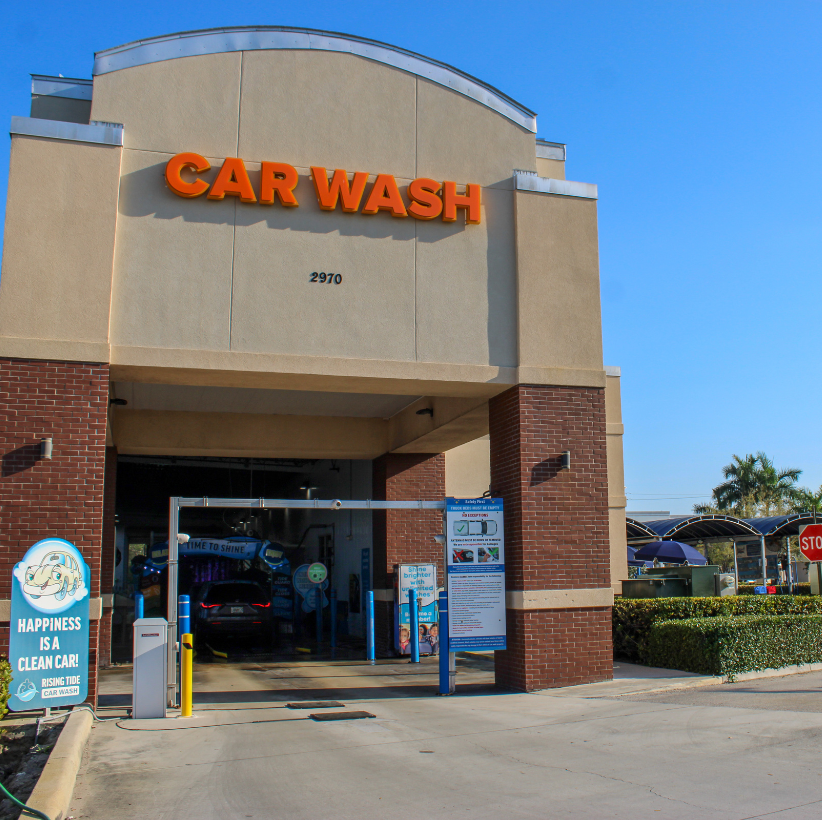 Rising Tide Car Wash Margate exterior with bold orange tunnel entrance and palm-lined plaza