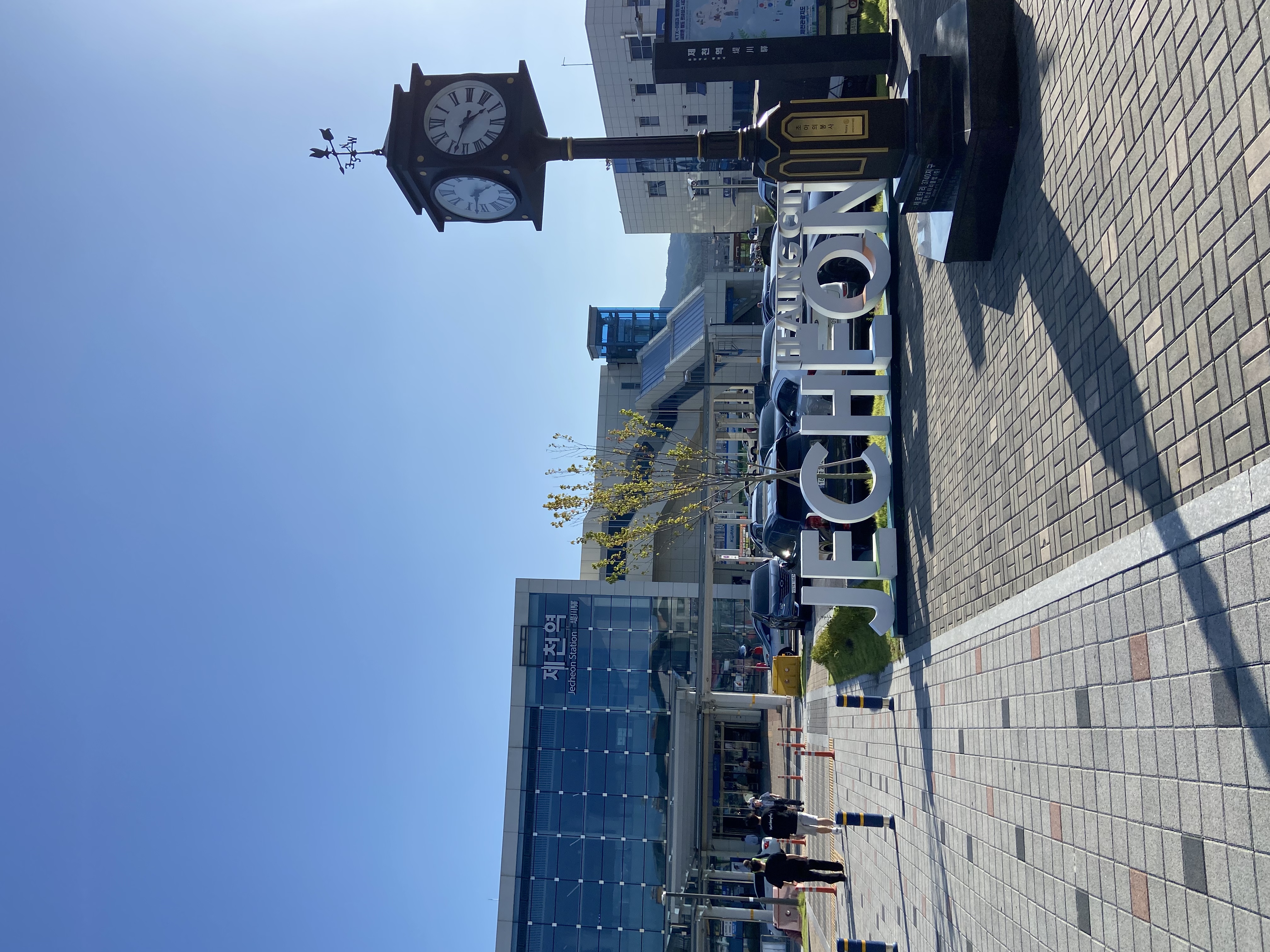 A clock and sign outside of Jecheon Station in Korea