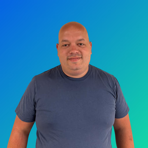 Portrait of a smiling man wearing a dark gray T-shirt against a blue-green gradient background.