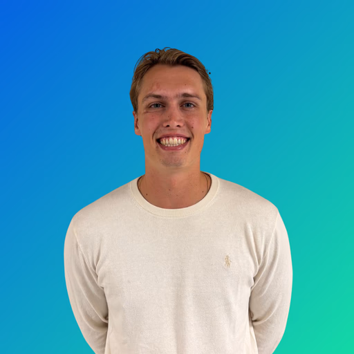 Smiling young man with short hair wearing a white sweater against a blue-green gradient background.