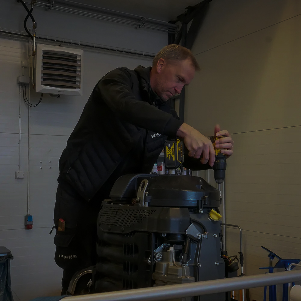 Roger står på ett knämedans han servar ett silvrigt drev.