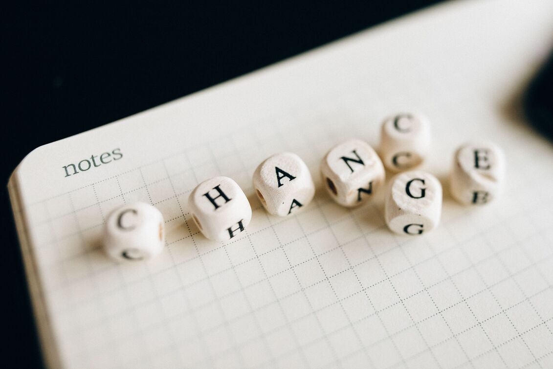 das Wort Change ist auf einem Notizbuch mit Würfeln dargestellt