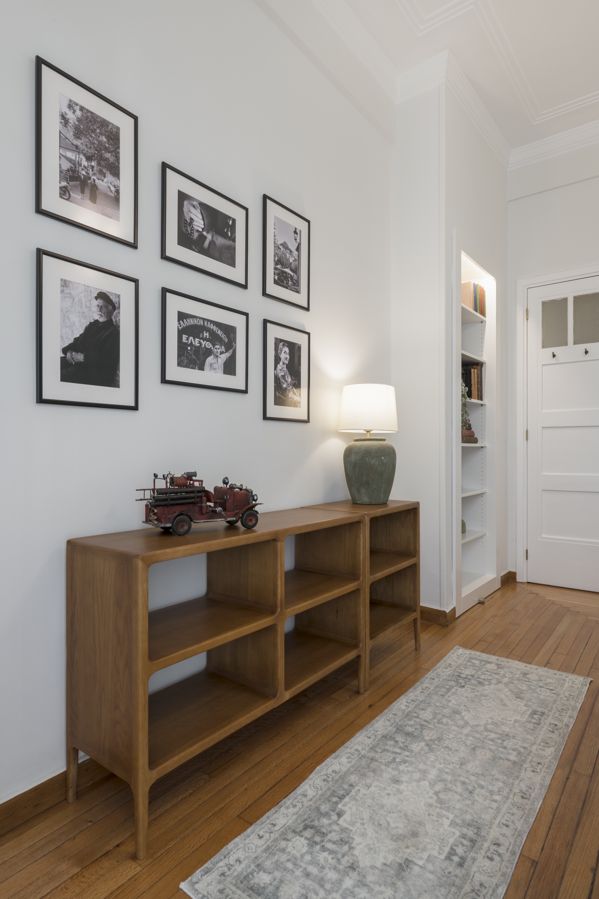 Bedroom detail with wooden console and framed prints at The Hive apartment in Kypseli Athens