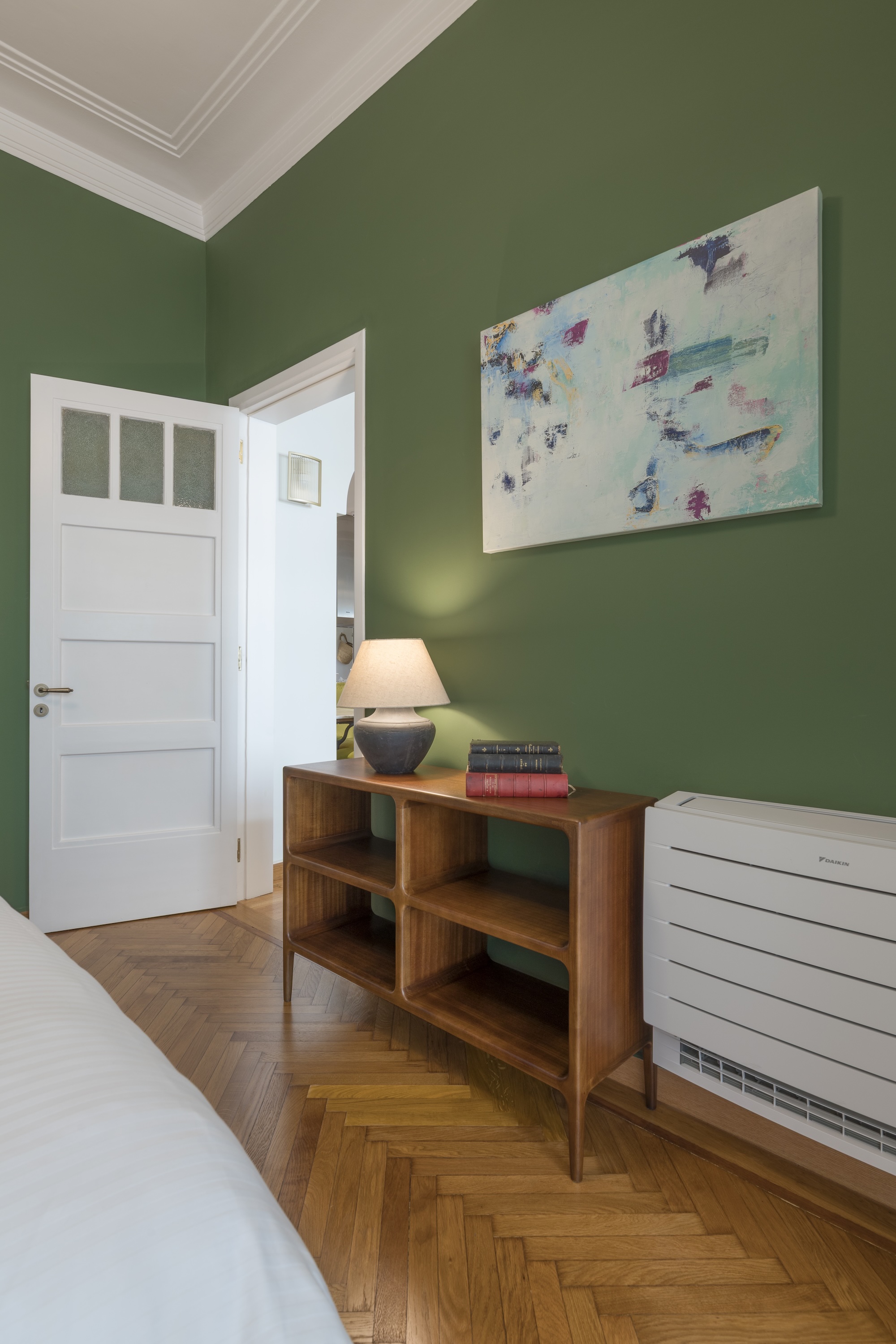 Bedroom corner with desk and green wall at The Hive apartment in Kypseli Athens
