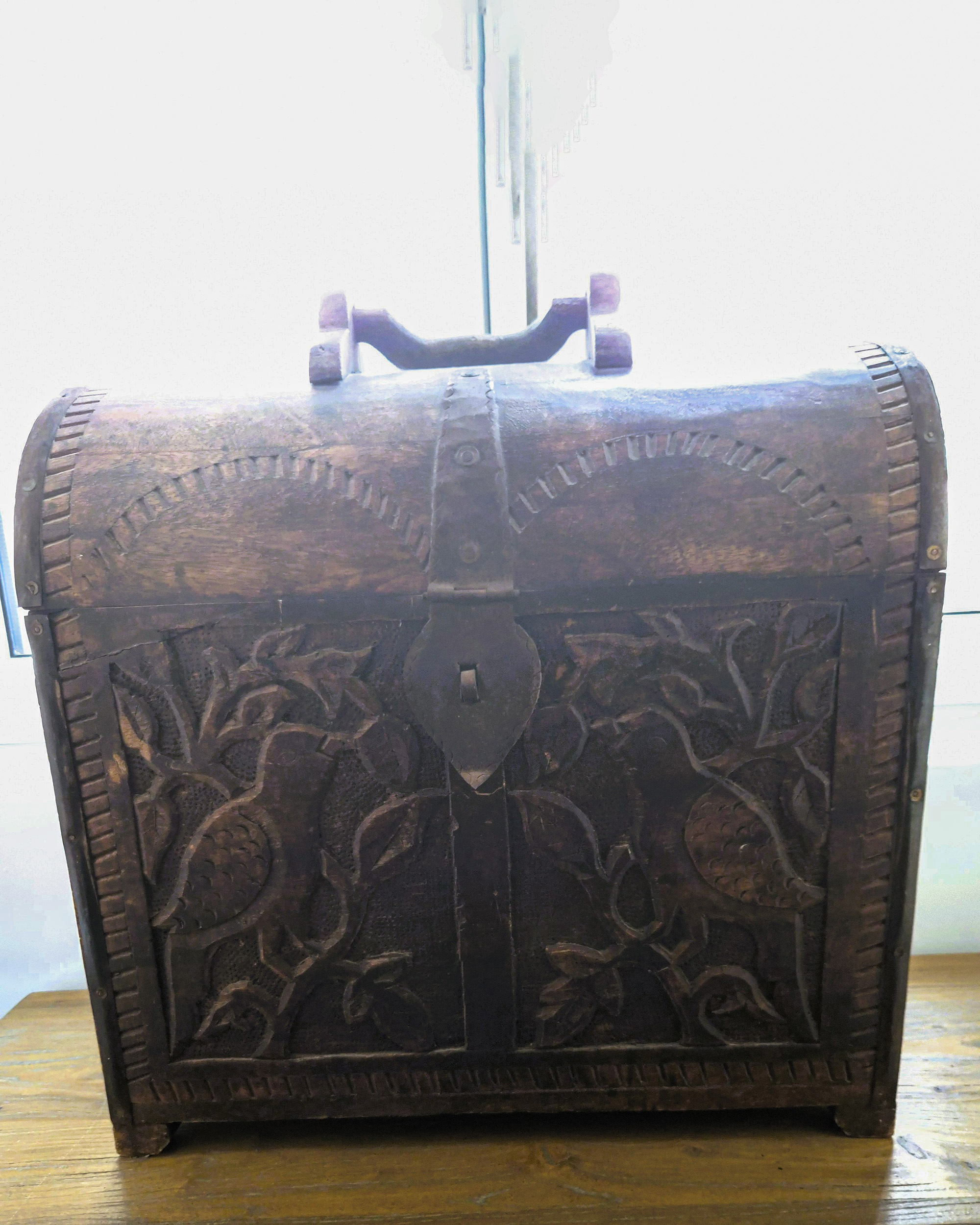 Hand-carved wooden chest with floral motifs at Silk House boutique accommodation in Metaxourgeio, Athens.