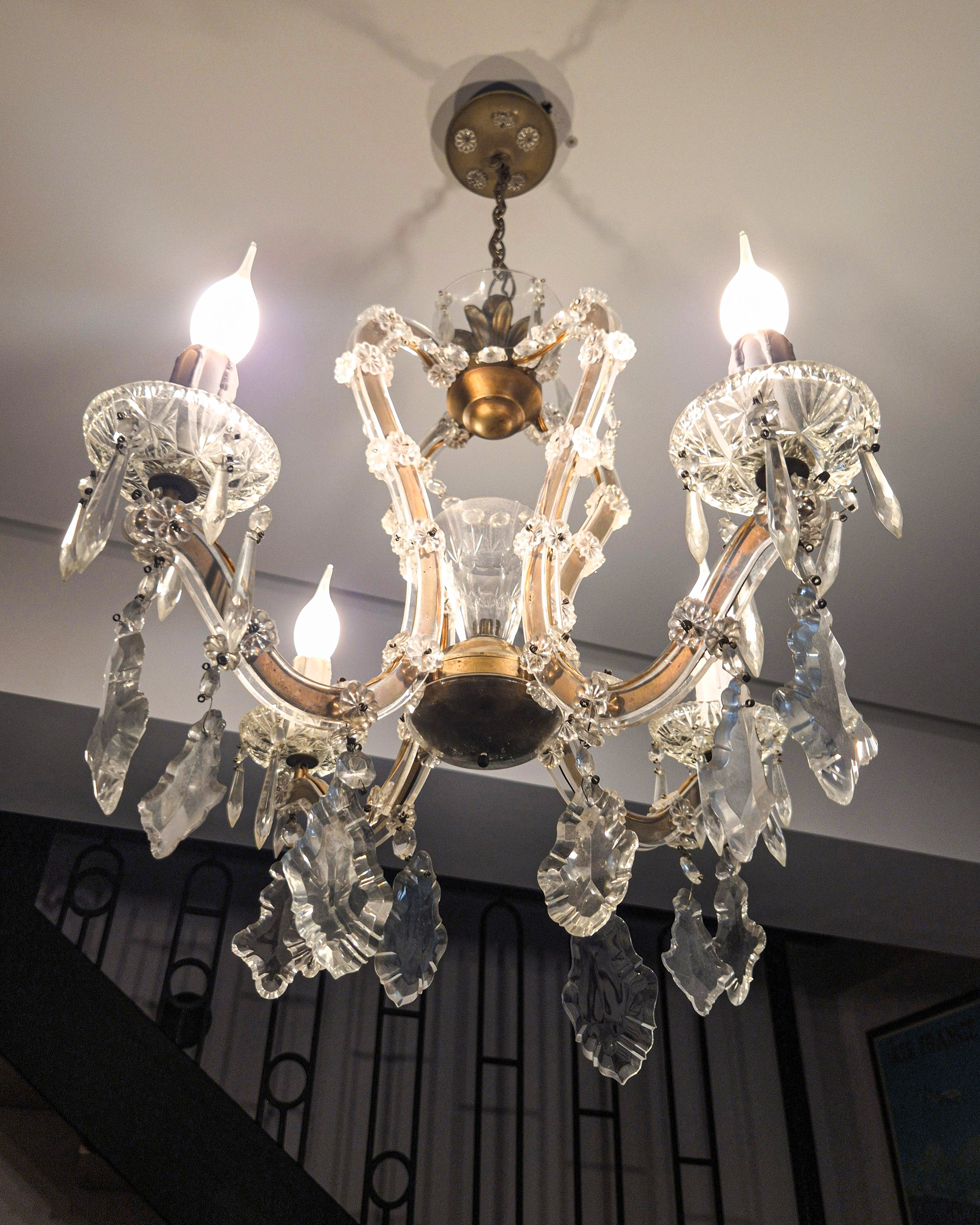 Crystal chandelier with glass arms and faceted pendants inside Silk House in Metaxourgeio, Athens.