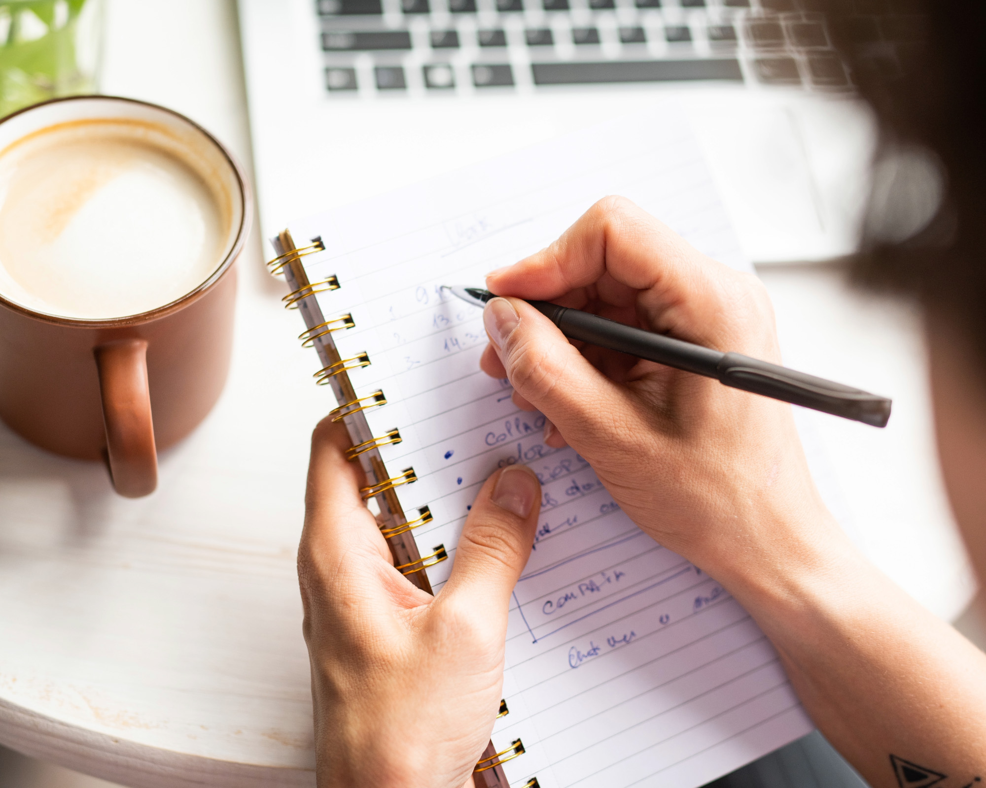 Person planning an Athens itinerary beside a laptop and cup of coffee