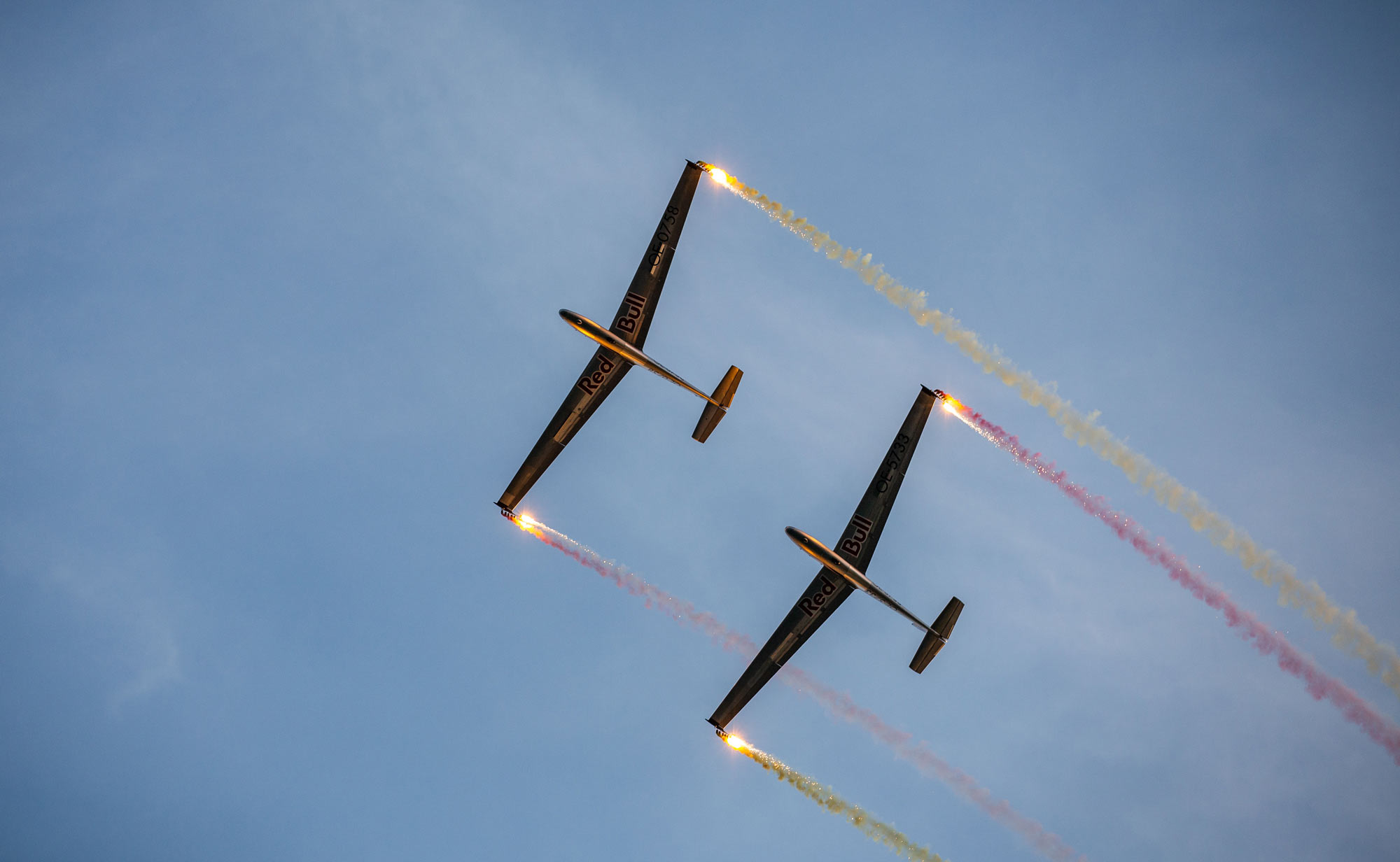 Segelflugzeuge des Red Bull Blanix Teams mit farbigen Rauchspuren bei der Flugshow über dem Wolfgangsee