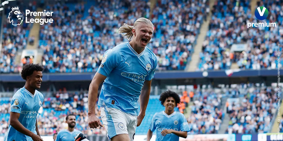 Manchester City-spillere jubler på fotballbanen under en Premier League-kamp med fullt stadion.
