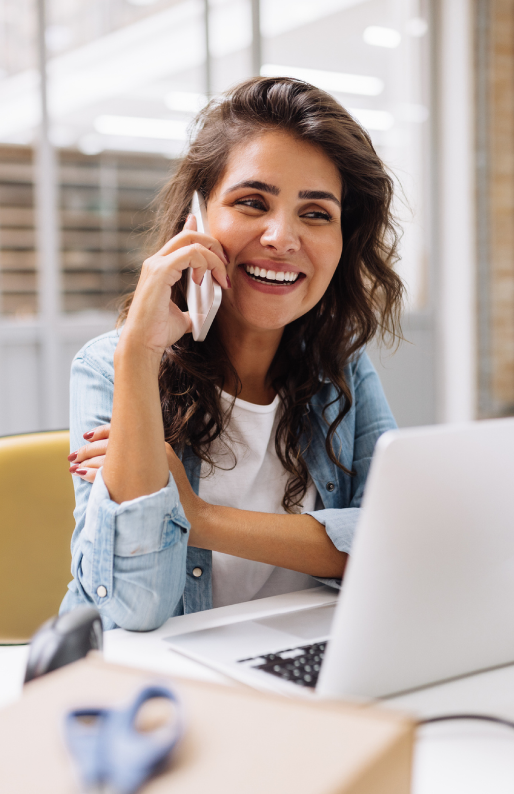 A smiling client on the phone, satisfied with her professional bookkeeping support.