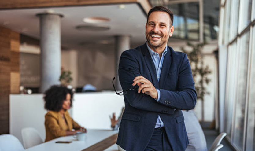A smiling business owner standing in a bright office, relieved after a professional bookkeeping cleanup.