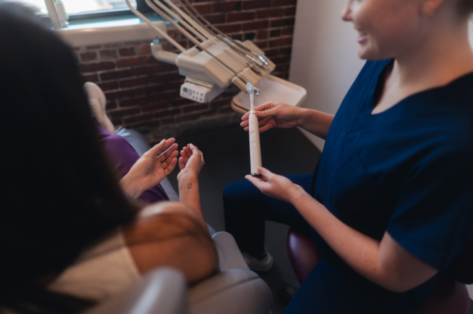 Dentist showing dental model to patient during consultation
