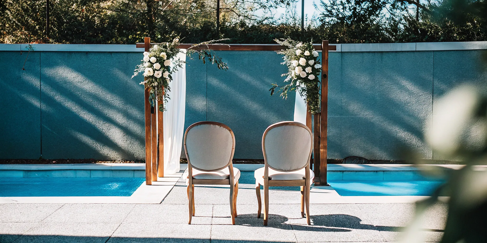 Simple wedding ceremony with a floral arch and two chairs, an intimate setting for a wedding script.