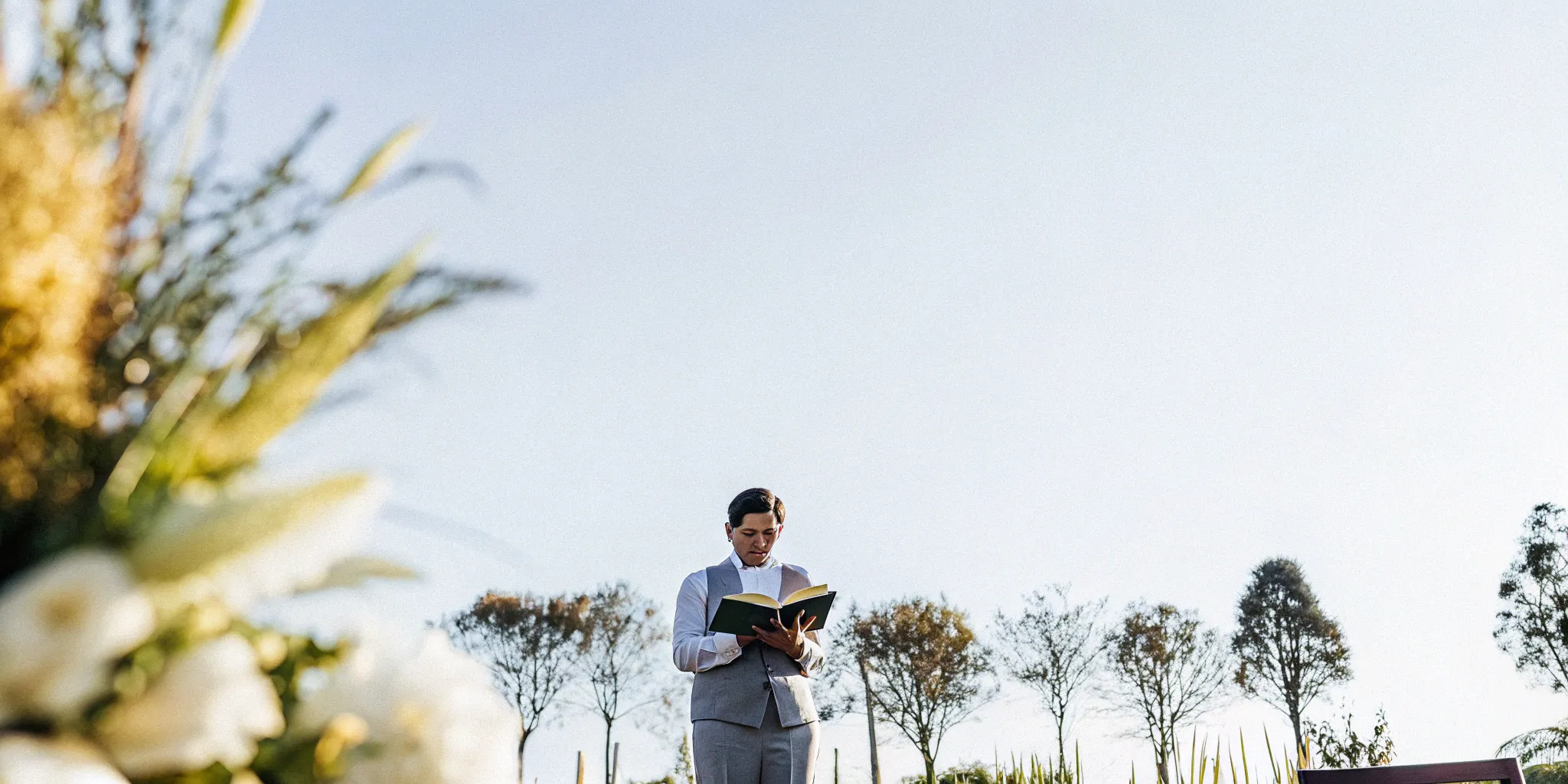 A wedding officiant prepared with training and certification reads from a ceremony book.