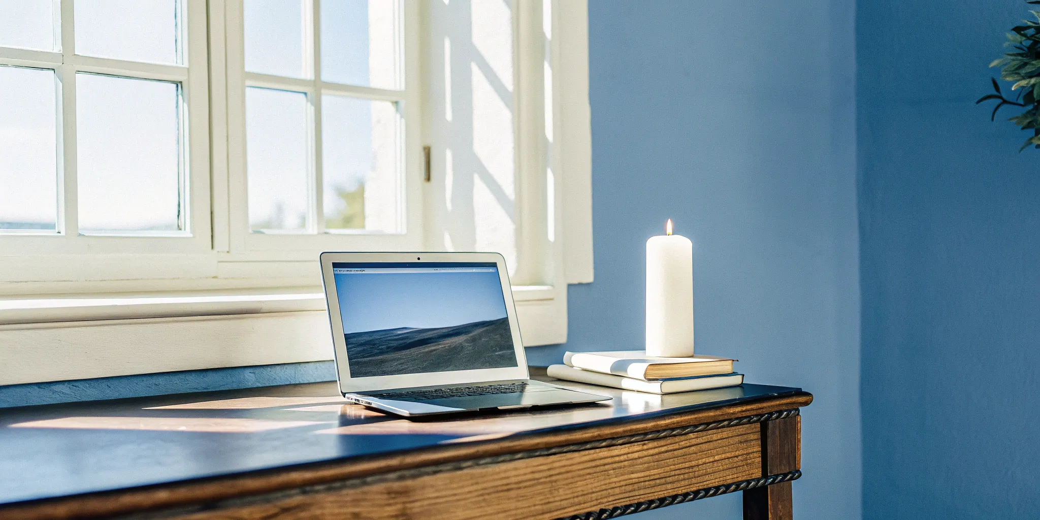 A desk with a laptop and books for someone studying to become a chaplain online.
