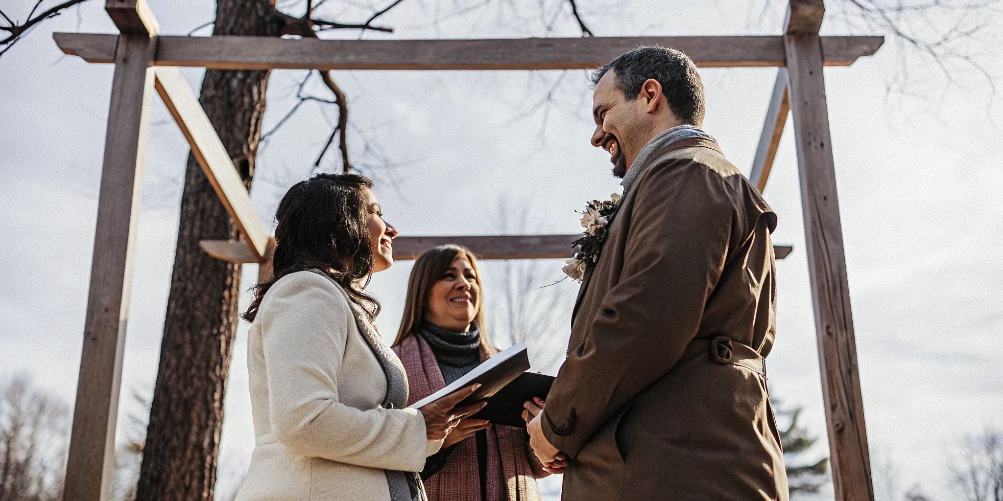 Officiant leading a bilingual wedding ceremony for a couple exchanging vows outdoors.