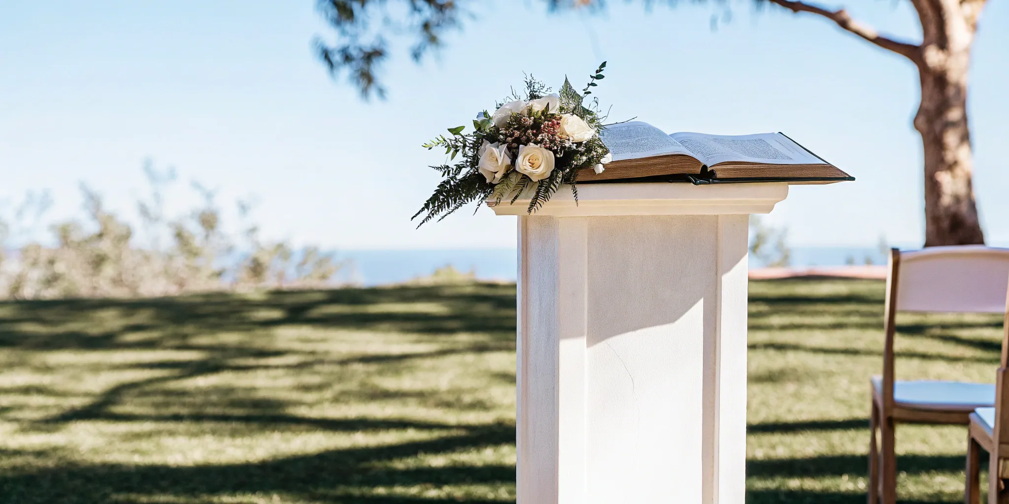 Wedding officiant's open book at a ceremony podium with flowers.