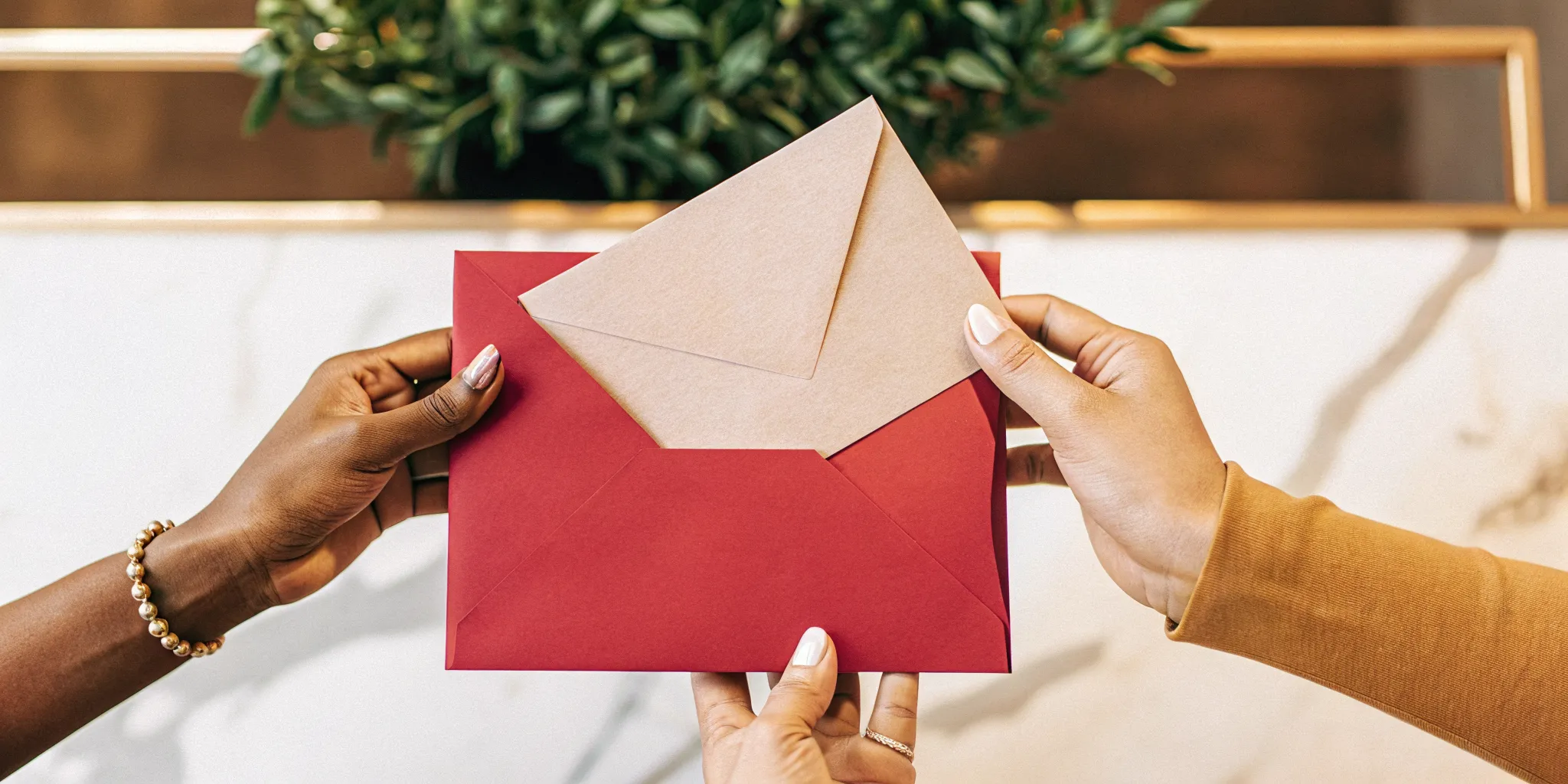 A person holds a love letter and red envelope for their wedding ceremony script.