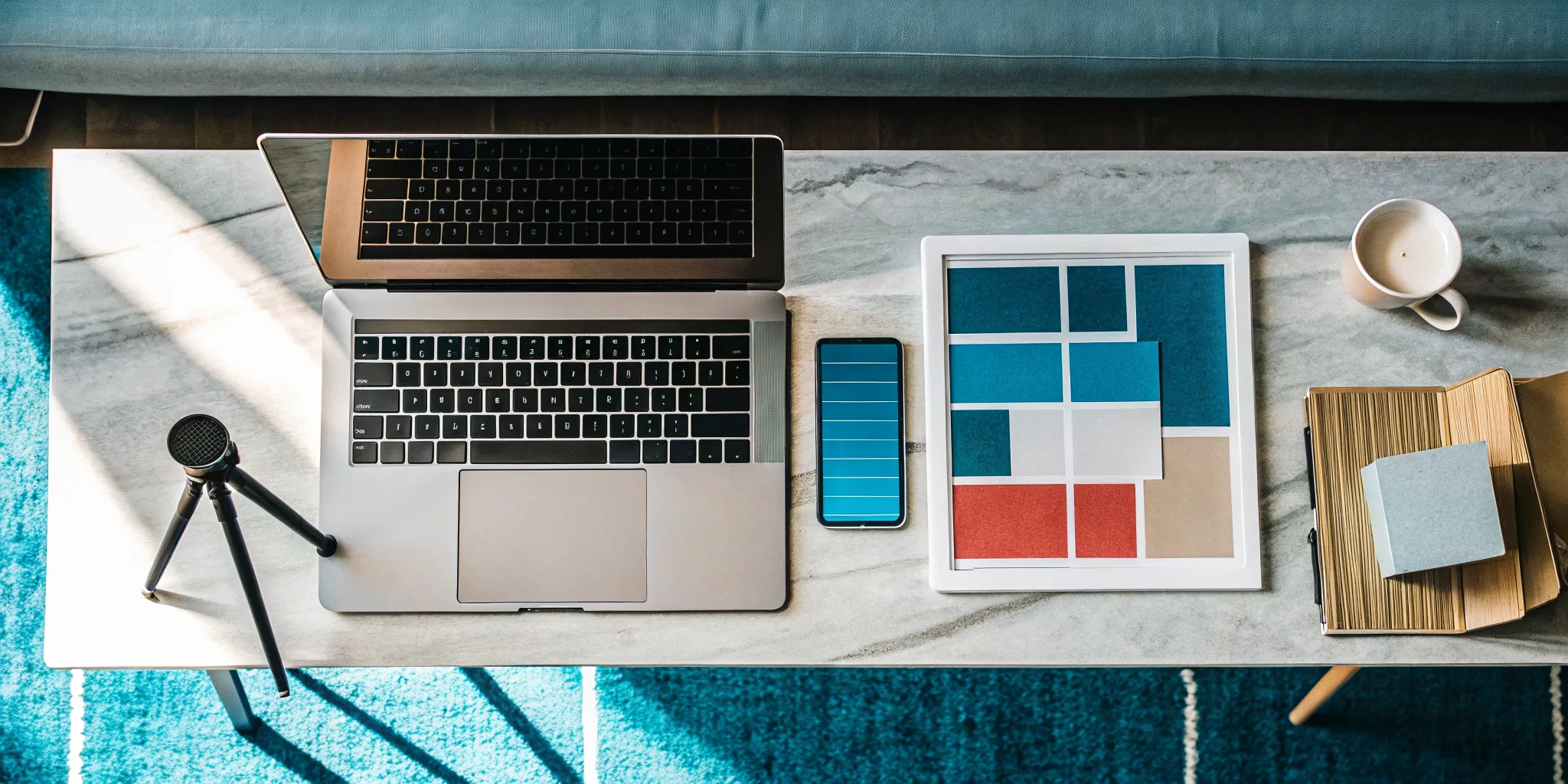 A desk setup with a laptop and microphone for launching an entrepreneurial side venture.