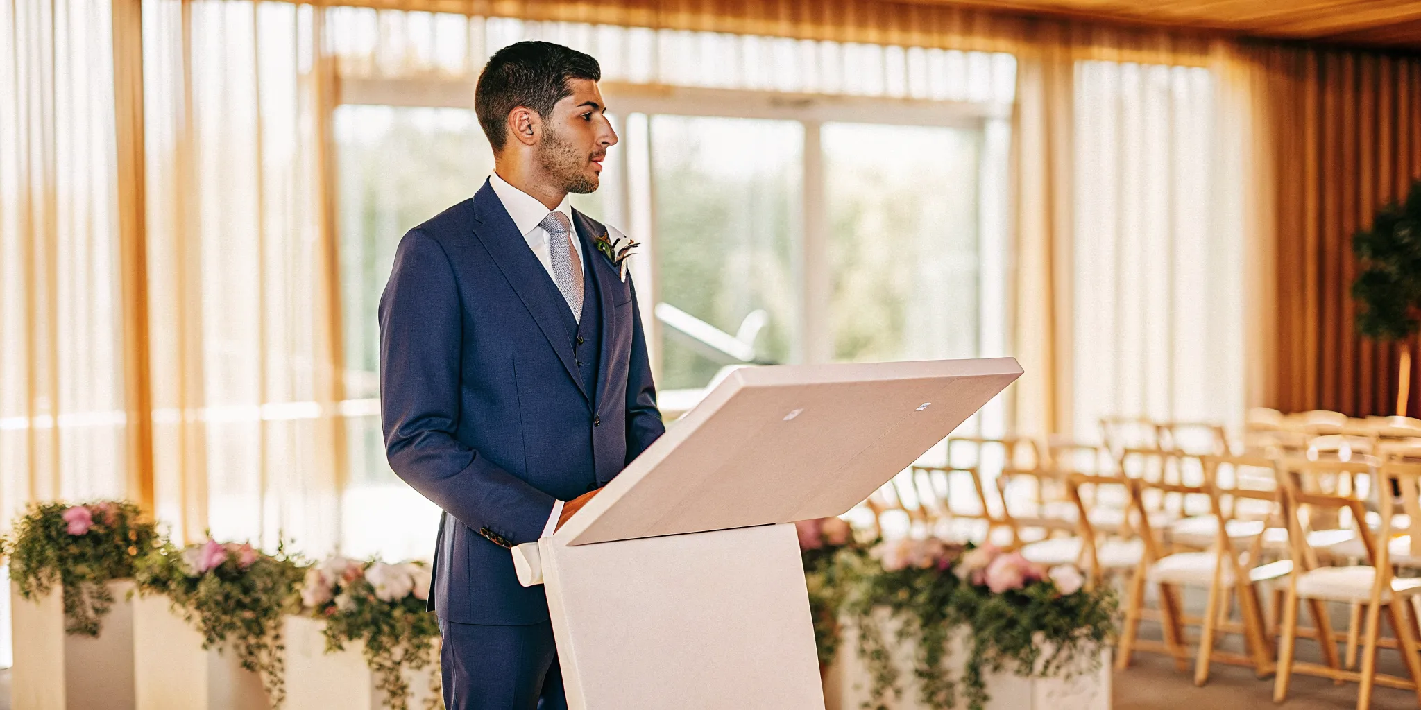 A wedding officiant practices at a podium in an empty venue to handle ceremony nerves.