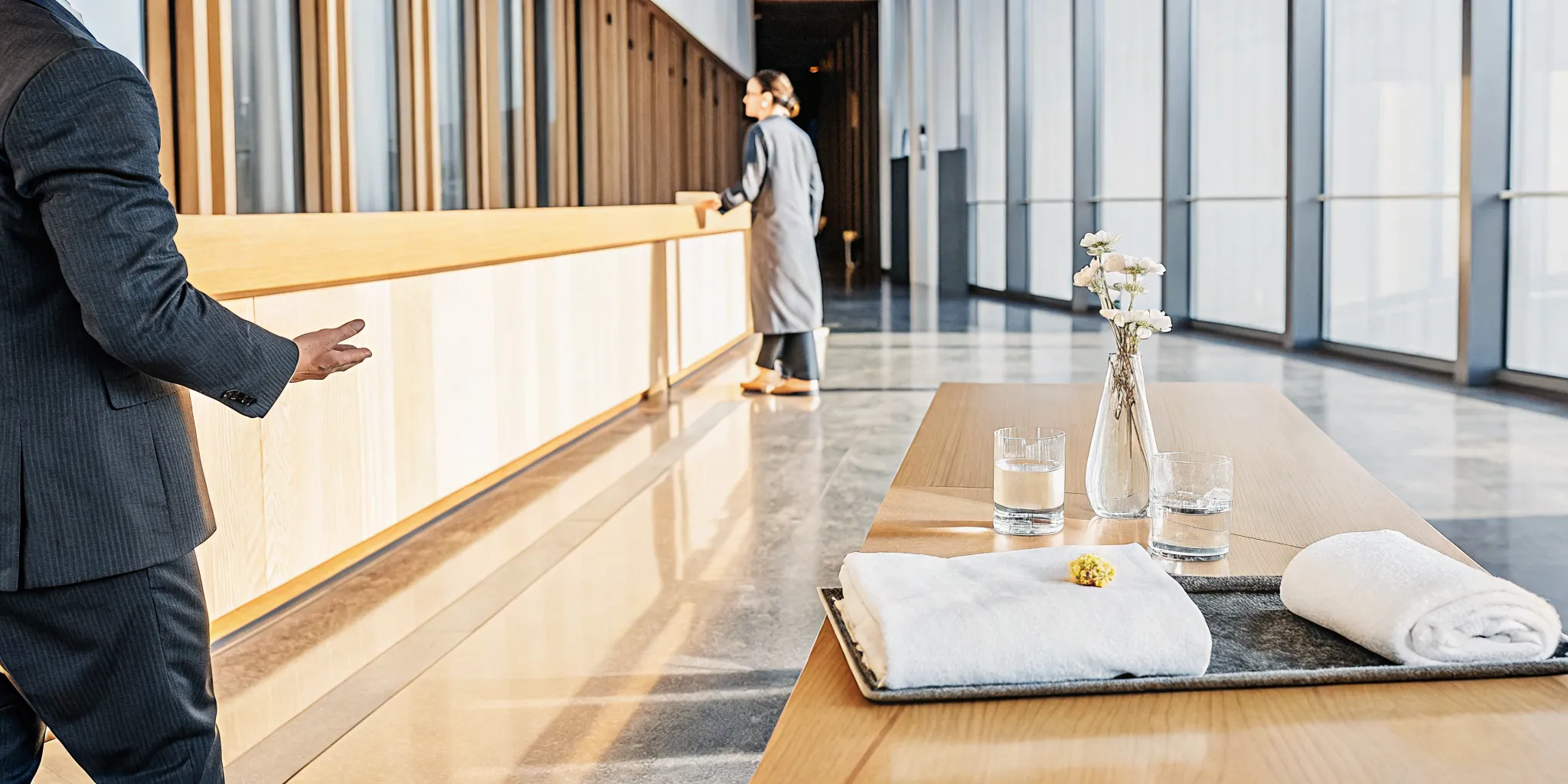 A modern entryway prepared with fresh towels, water, and flowers to welcome guests.