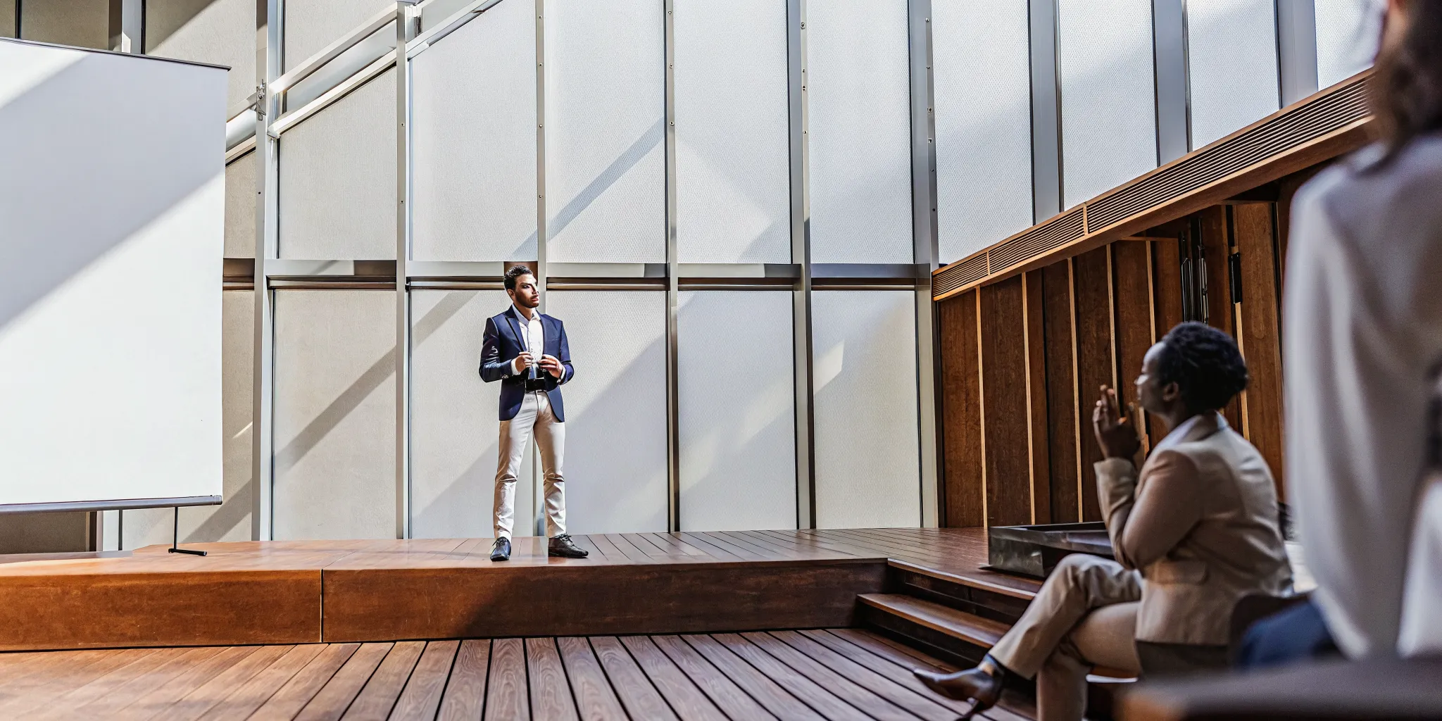 A public speaker with good posture projecting his voice to an audience.