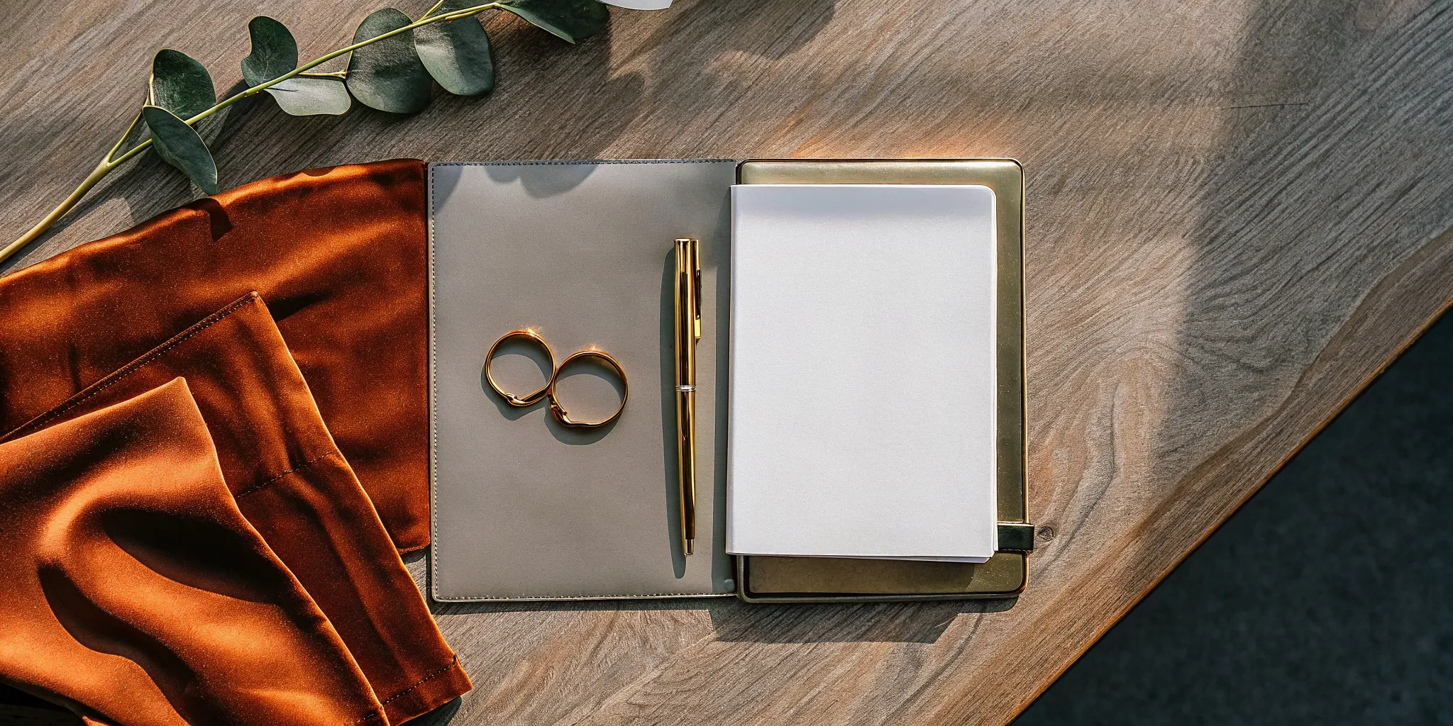 An officiant plans a simple wedding ceremony template with a notepad, pen, and gold rings.