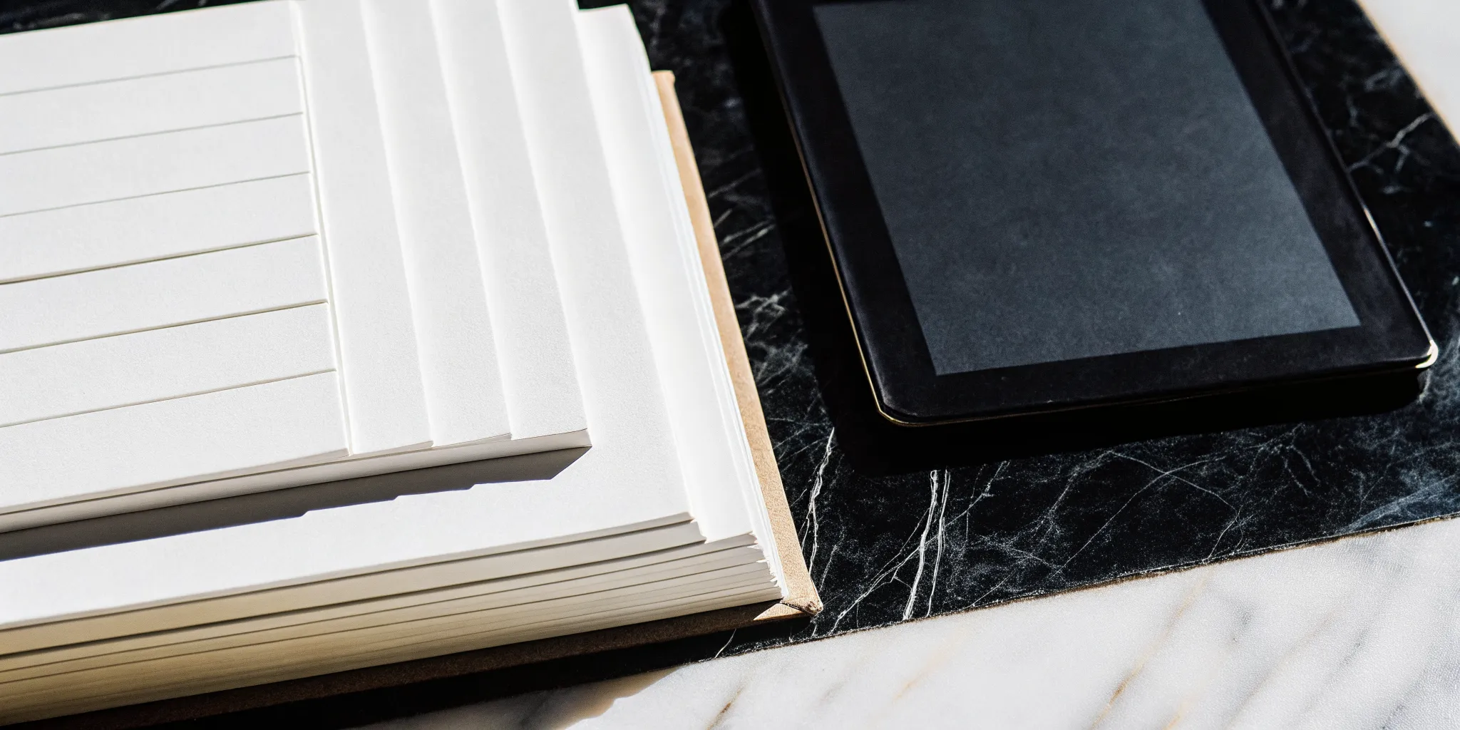 A modern wedding ceremony template notebook open for planning next to a tablet.