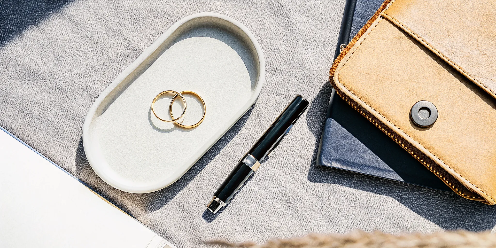 Gold wedding rings on a dish with a notebook for writing short ring exchange wording.