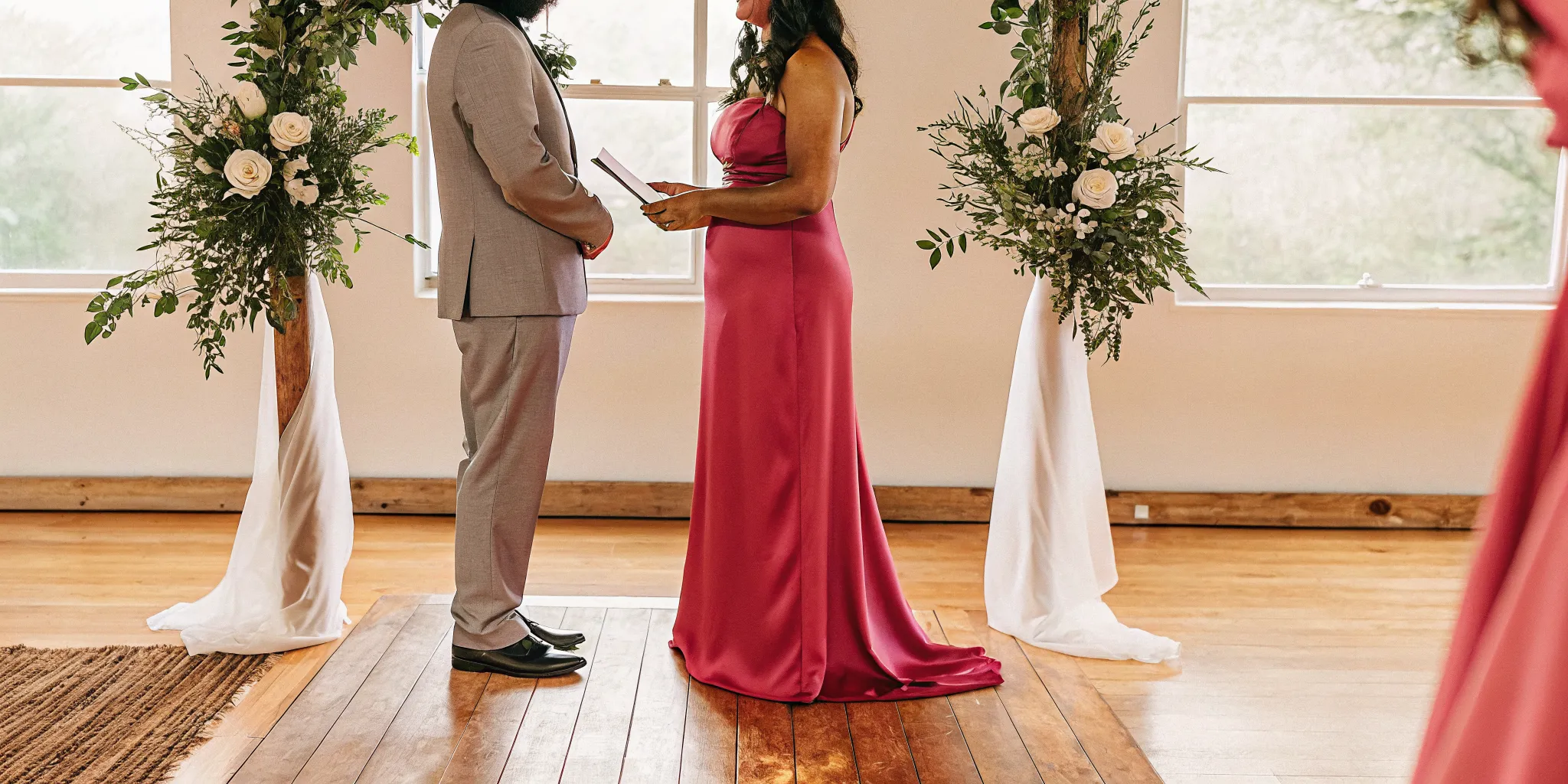 An officiant leads a wedding ceremony for a couple, reading from a script.