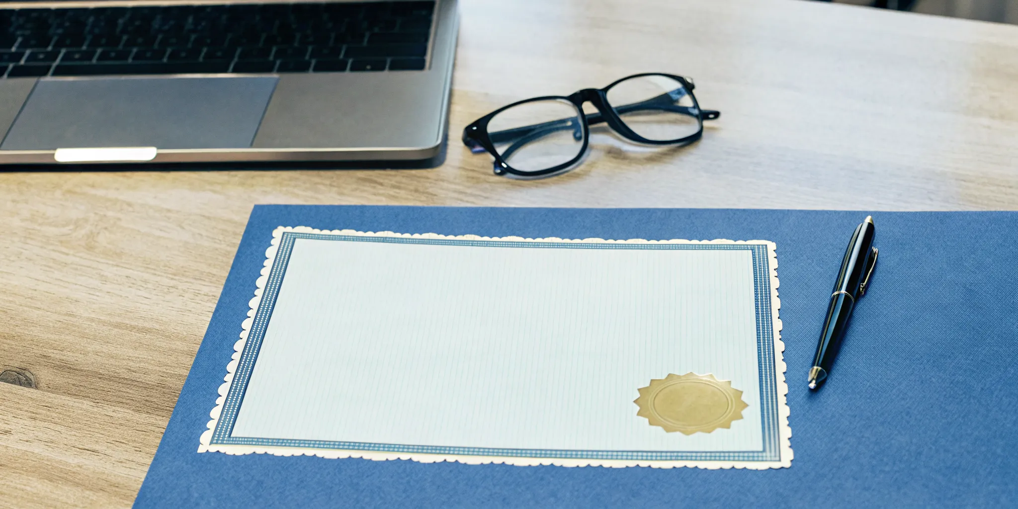 Free ordained minister certificate on a desk with a laptop.
