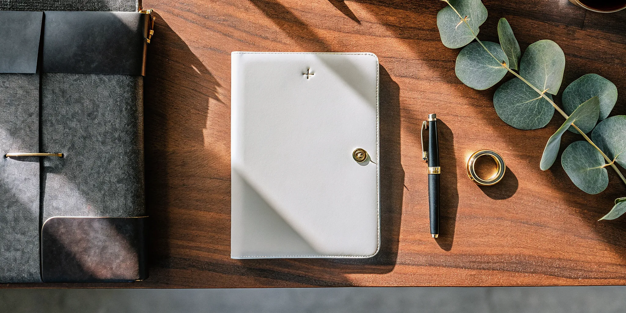 A planner open to a short Christian wedding script, with a pen and gold rings on a table.