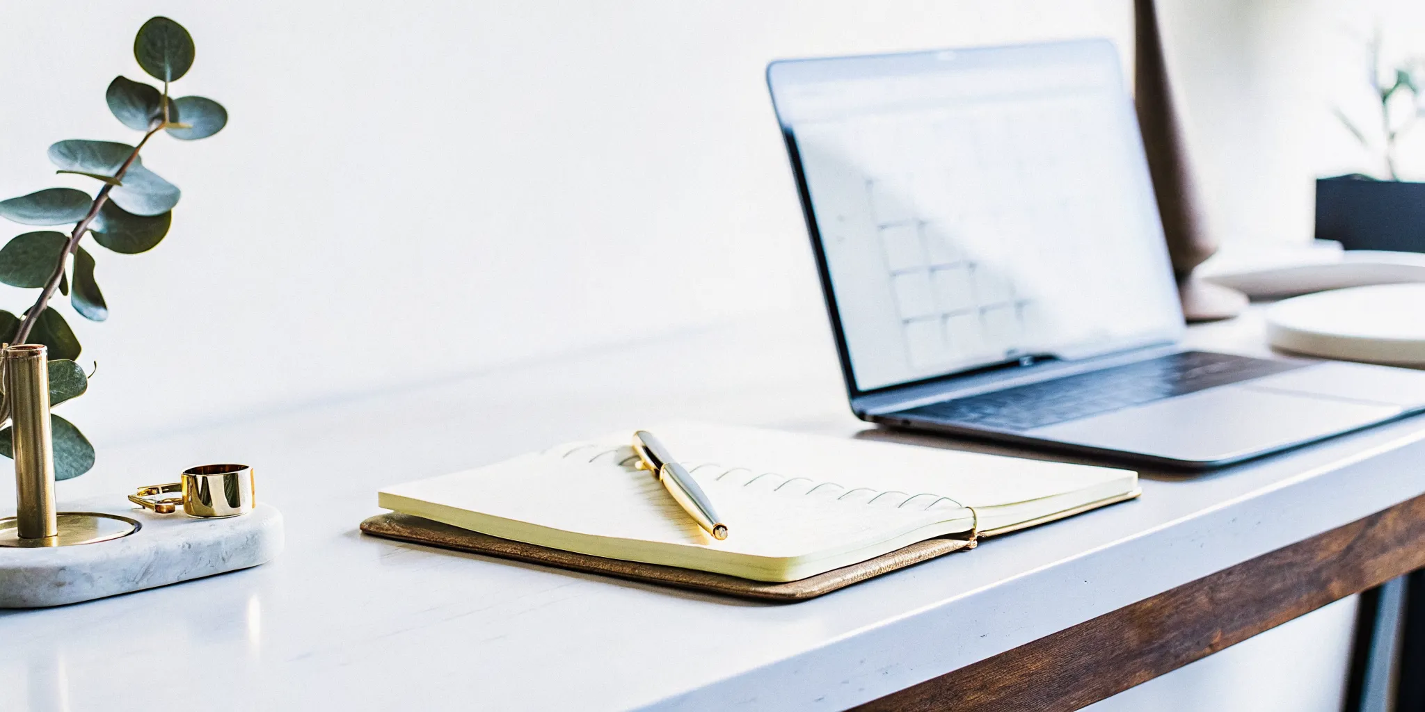 Laptop and notebook on a desk for an online certified wedding officiant course.