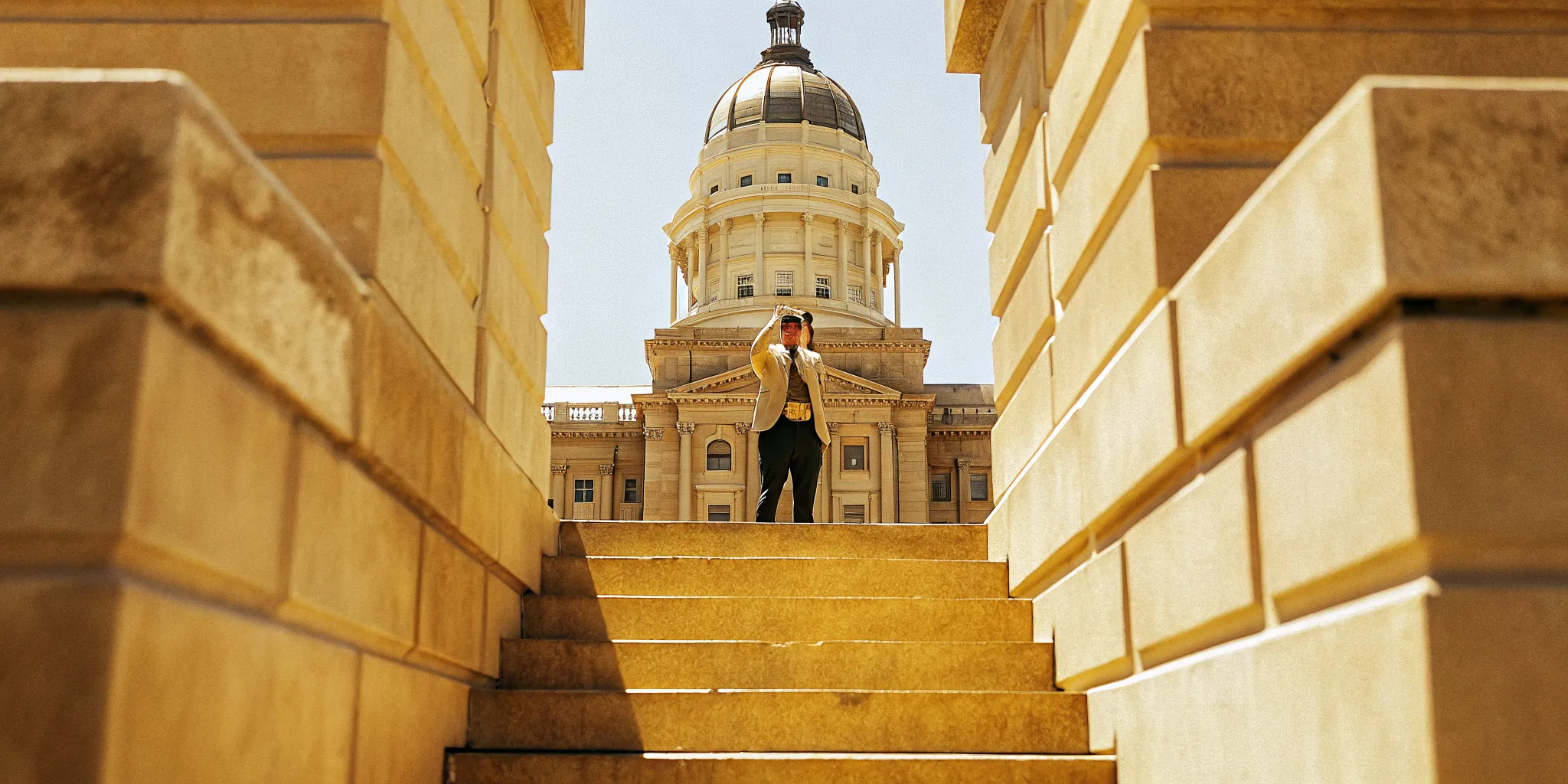 Person holding an ordination certificate in front of the Indiana State Capitol building