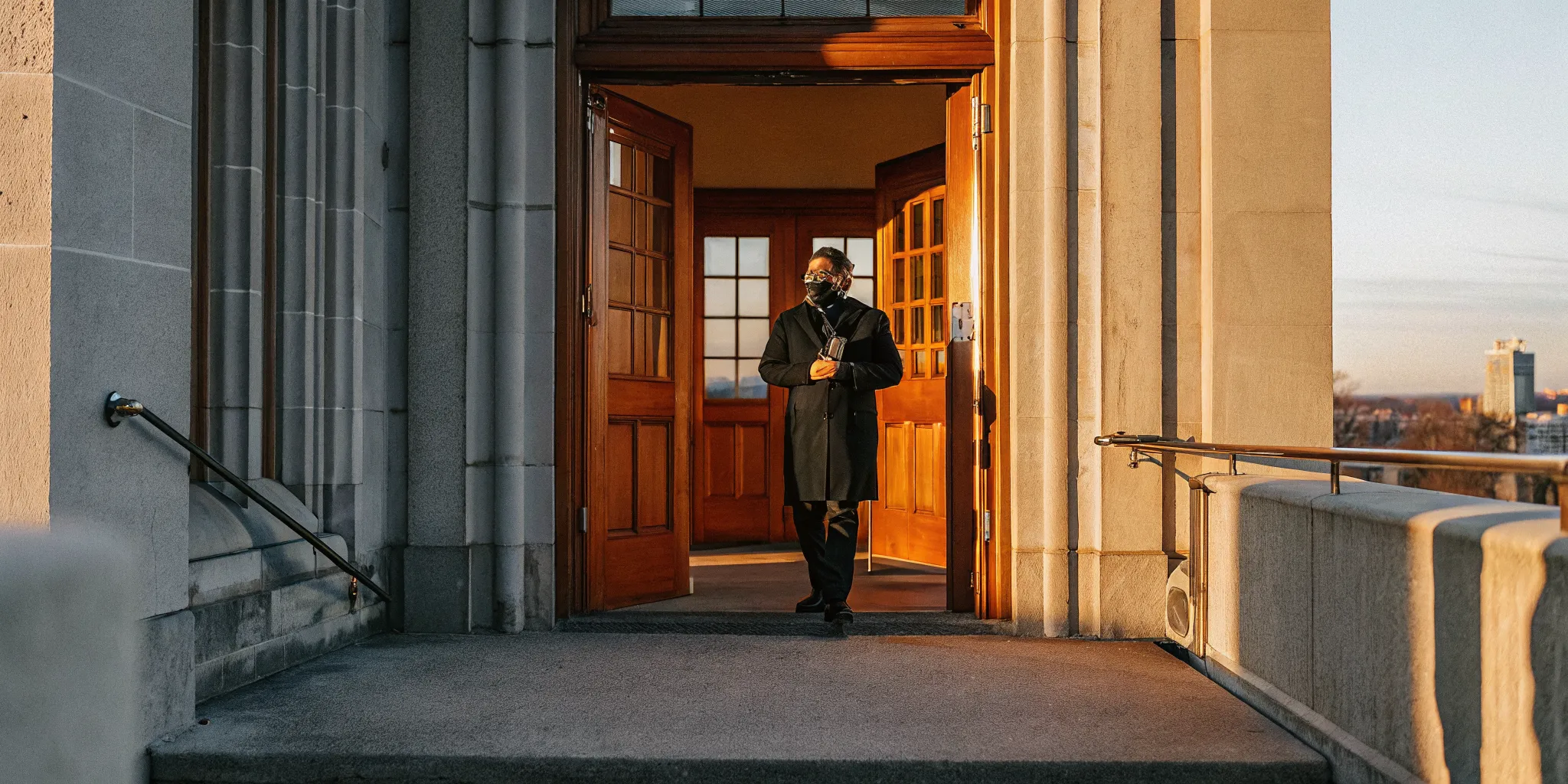 Newly ordained minister in formal attire outside a Minneapolis government building holding ordination credentials