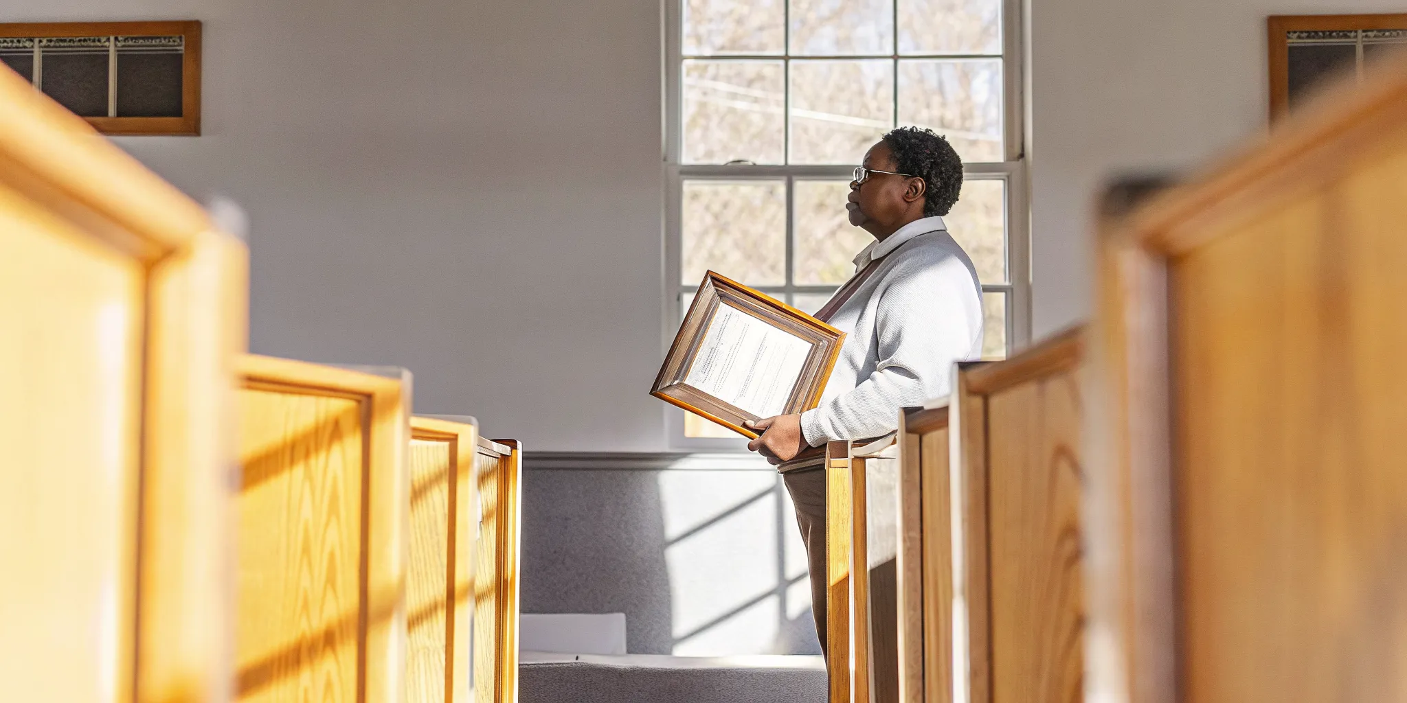 Ordained minister holding an ordination certificate in a South Carolina sanctuary