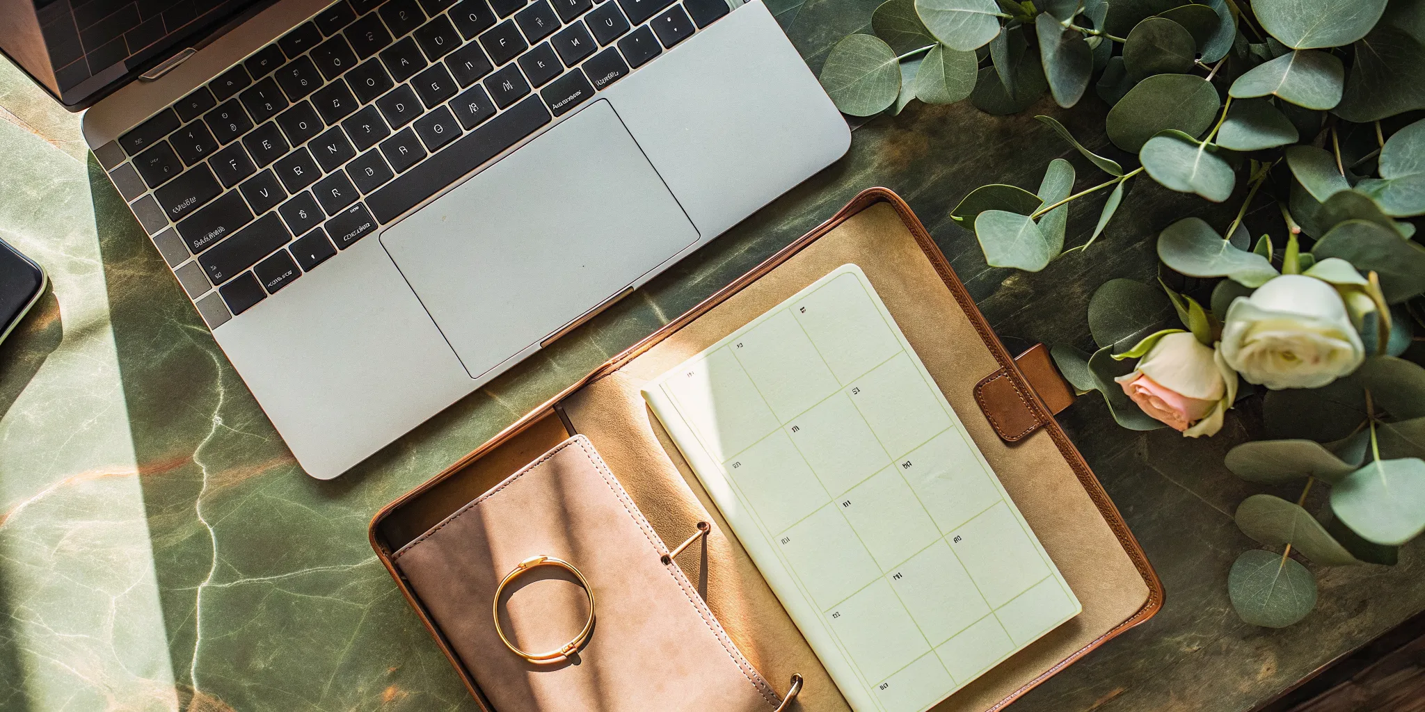 Laptop and planner used by a wedding officiant to book their first paid wedding.